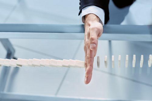 close-up. businessman hand stop dominoes continuous toppled. business concept.